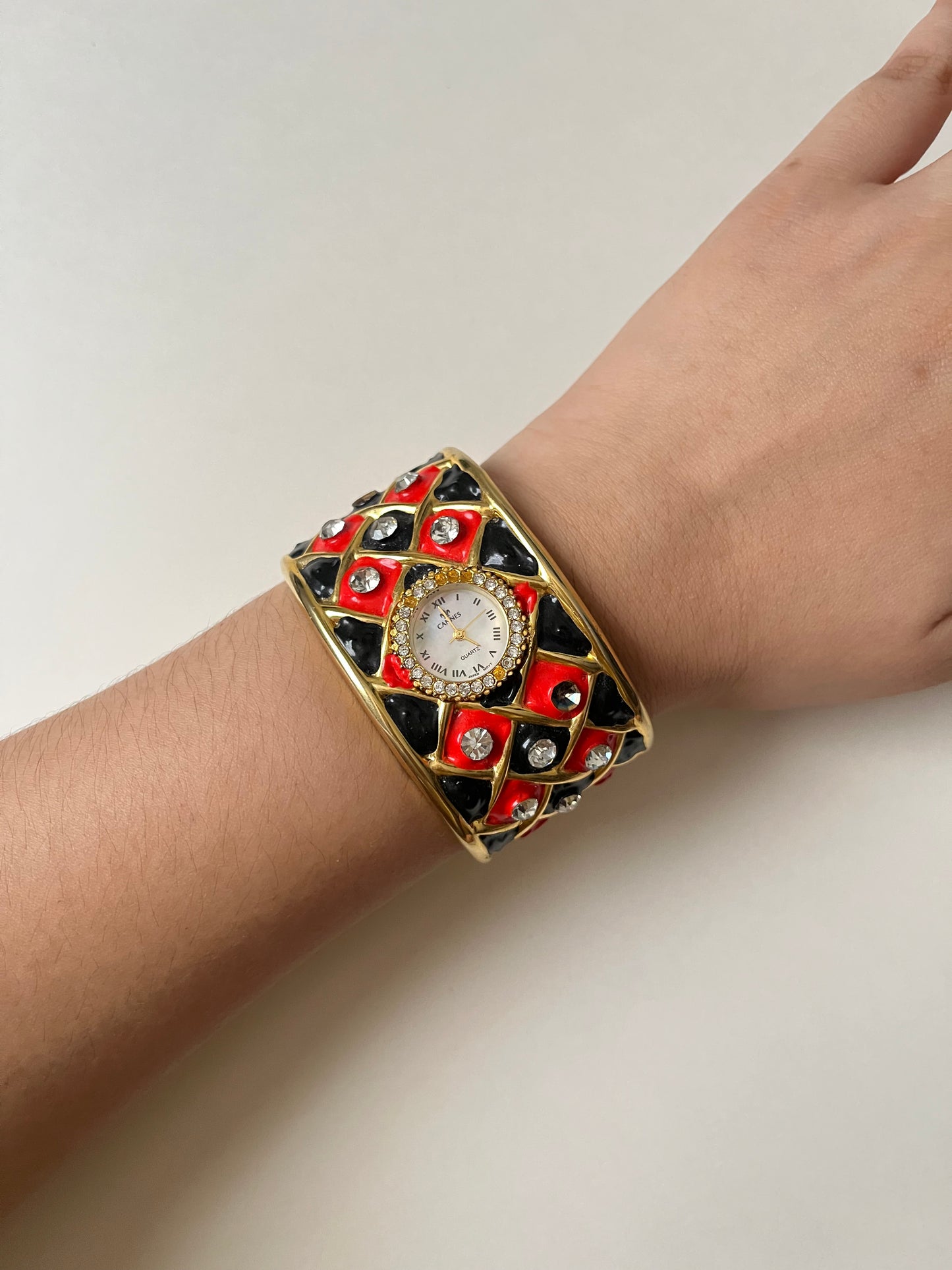 Striking Gold Tone Chunky Cuff Watch with Red and Black Checkerboard Design