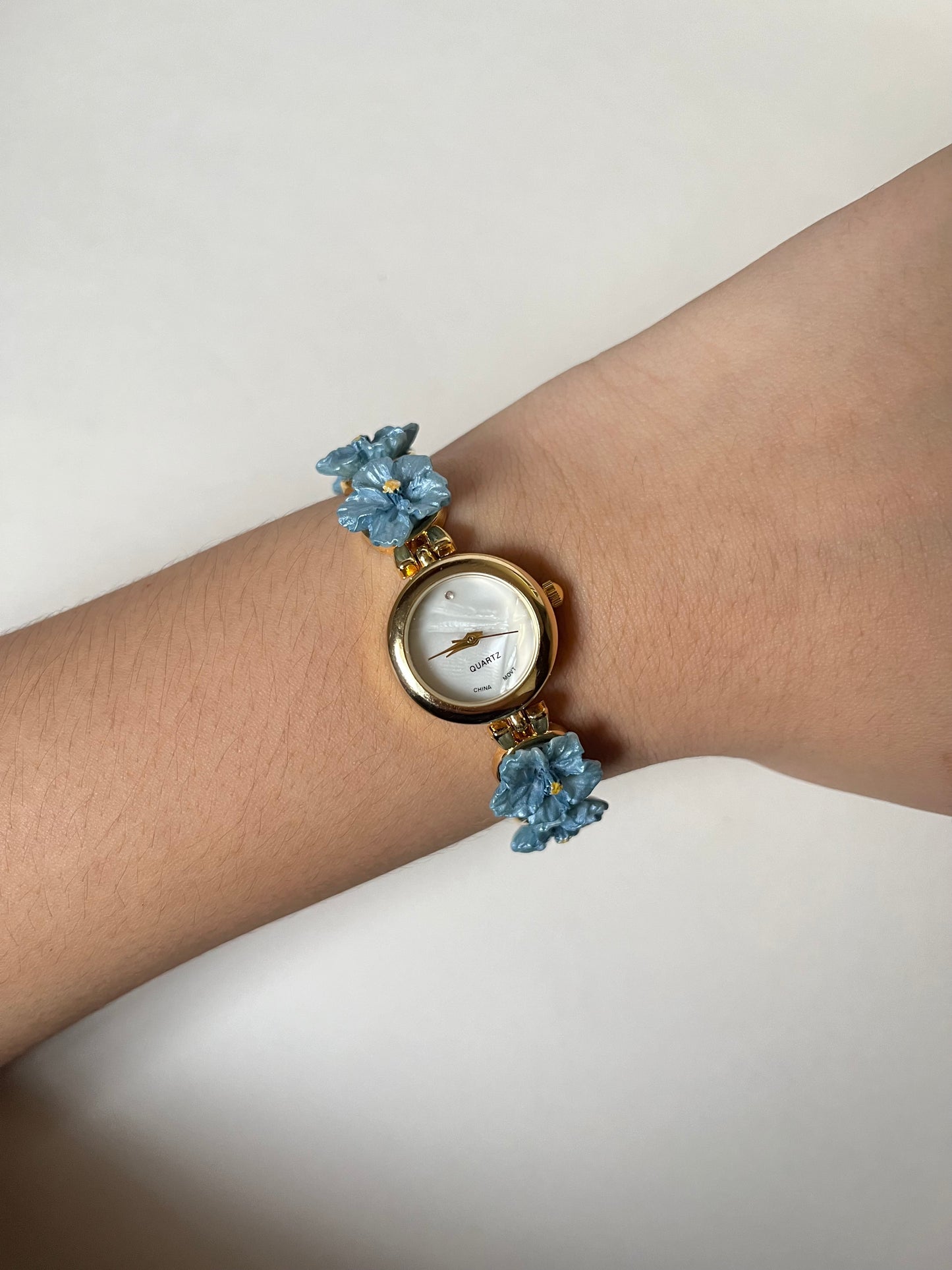 Adorable Gold Tone Watch with Round Dial and Blue Hibiscus Floral Links